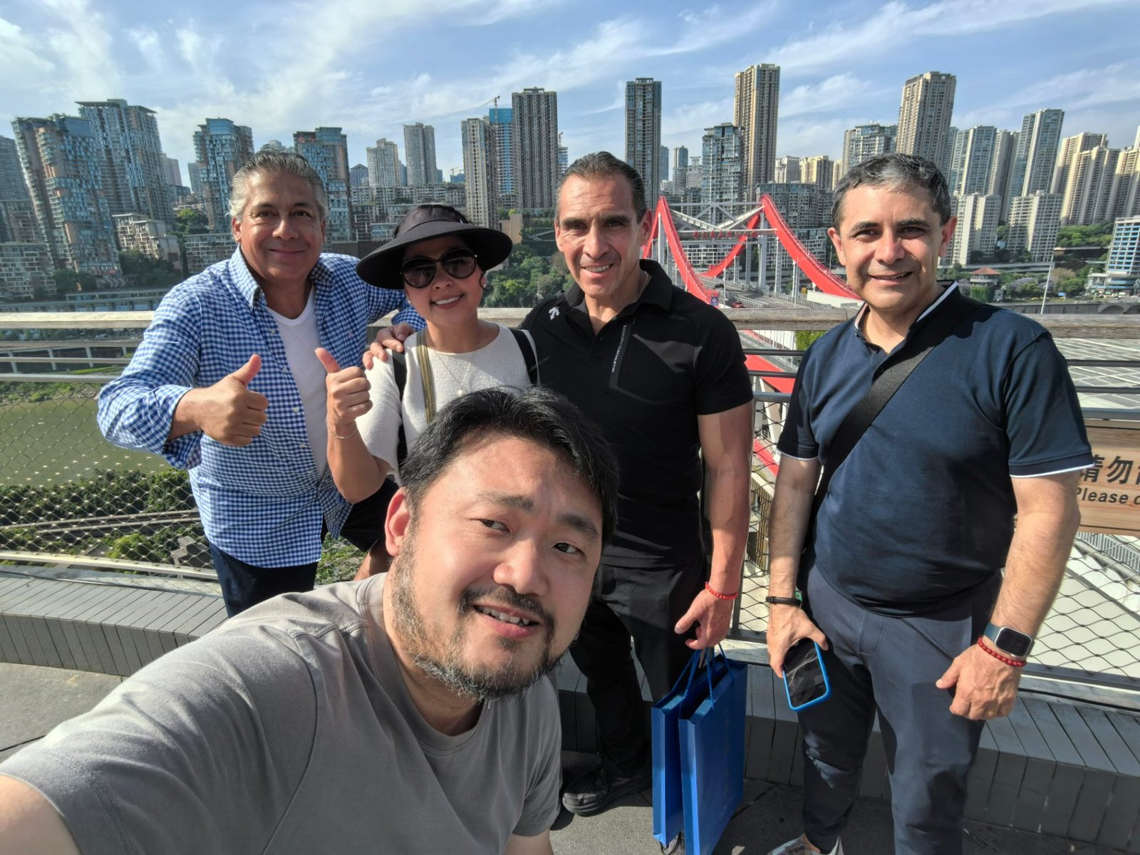 Group of travellers with their 71Asia guide on a rooftop over the bridges of Chongqing at dusk